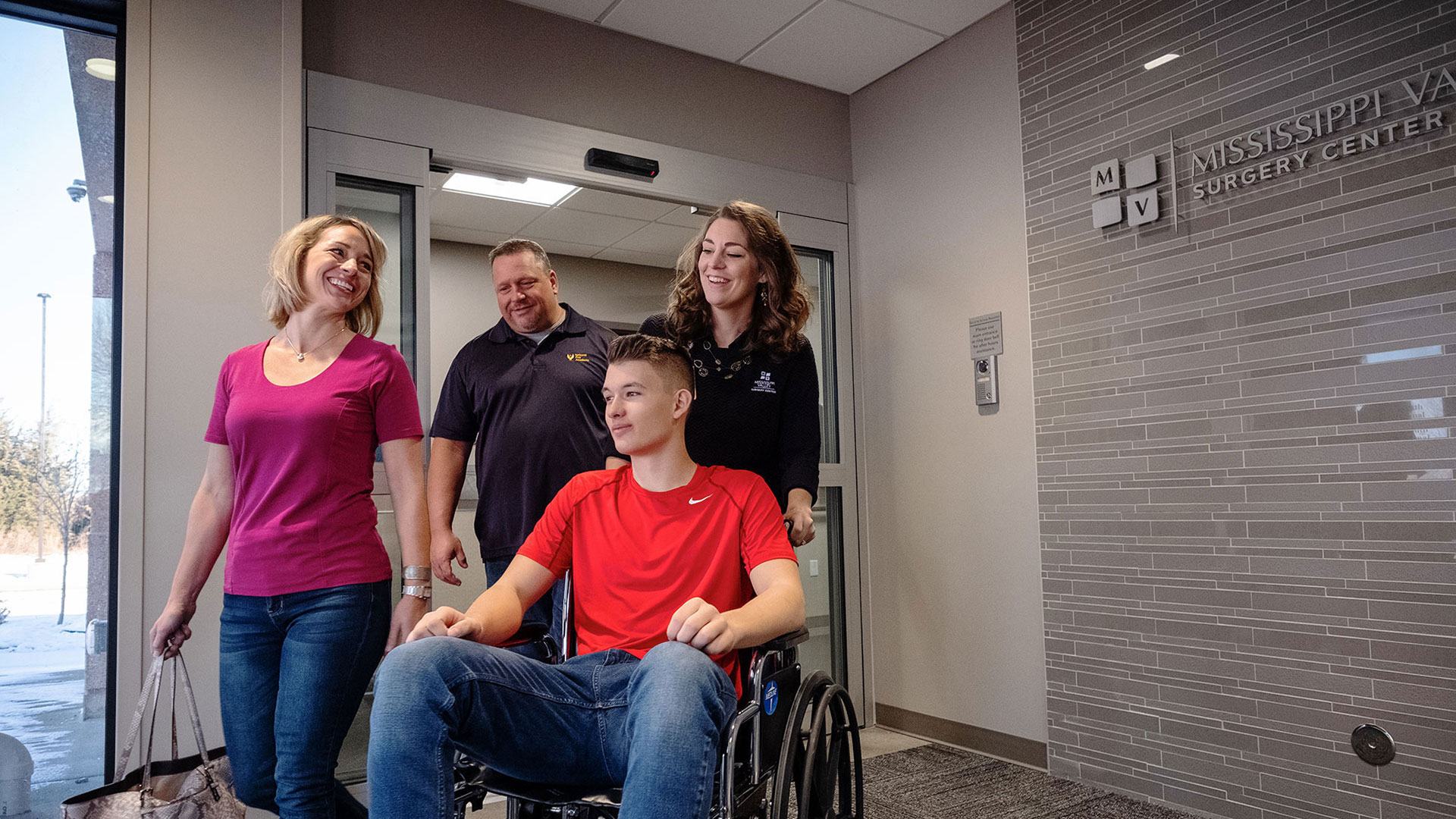 teenager in wheelchair with his family