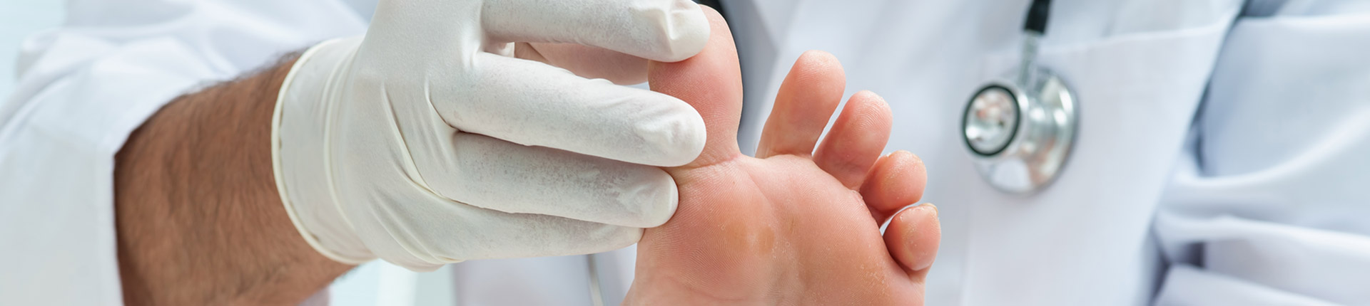 toes being touched by doctor with rubber gloves